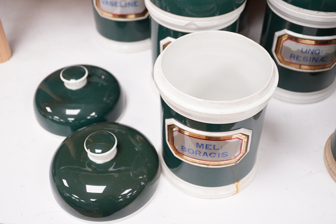 A collection of sixteen 19th/early 20th century ceramic lidded green apothecary jars, with labels painted within panels with raised ceramic edges and gilt lined, examples including; Ung: Zinci, Ung: Sulphur:, Mel: Boraci